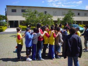 Crianças fazendo o "trenzinho da massagem", uns massageando os ombros dos outros no intervalo escolar. Um dos exercícios para os olhos em crianças!